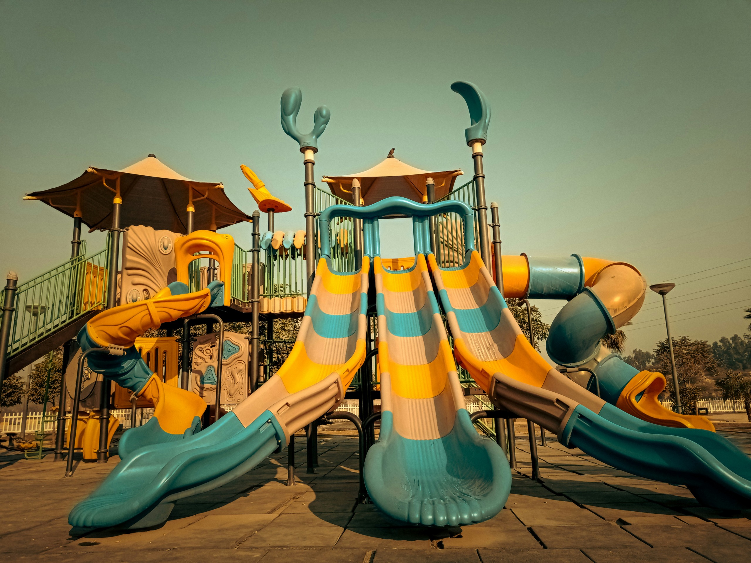 a playground with a slide and play structure | photo by fahim junaid