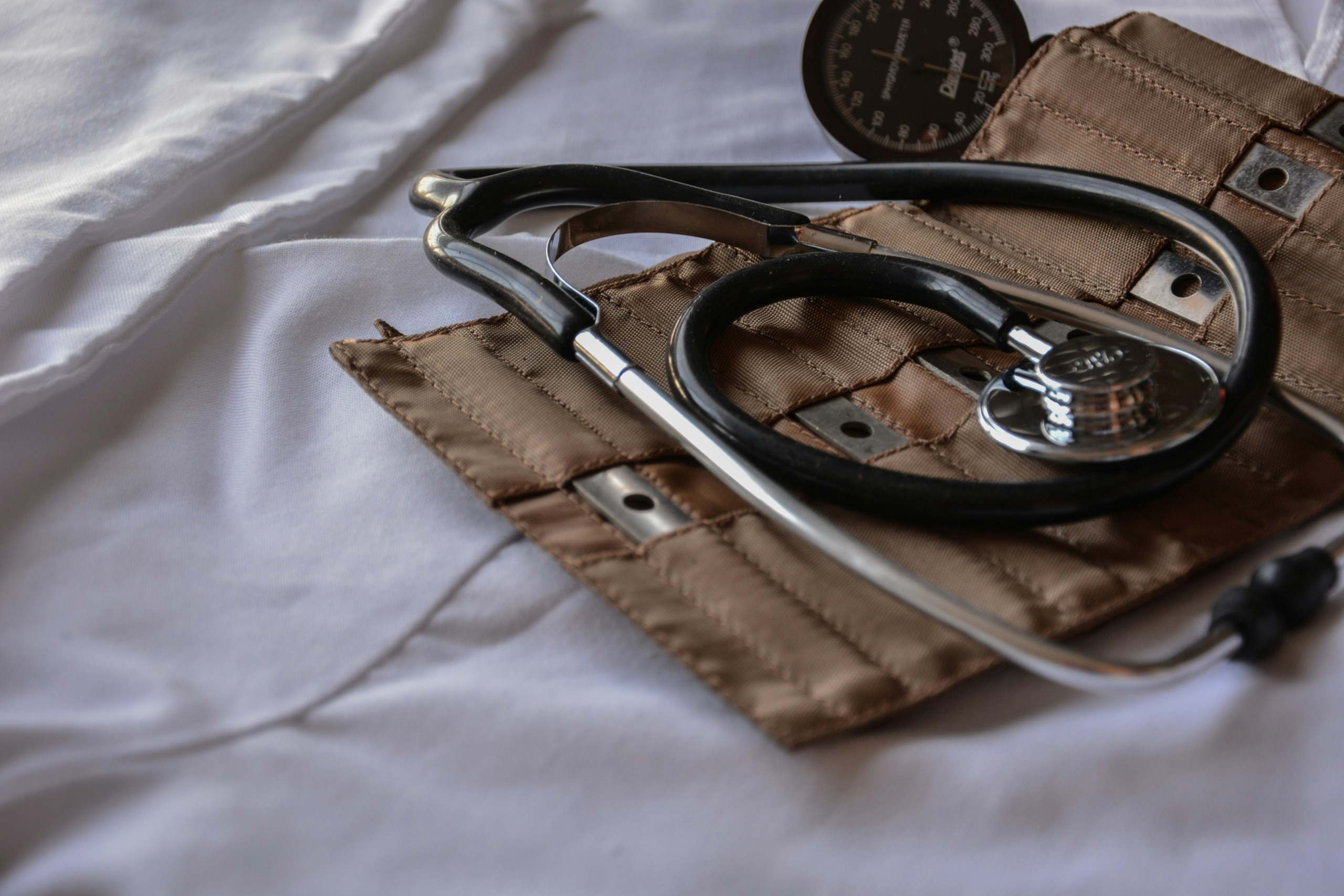 black stethoscope with brown leather case - photo by marcelo leal