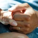 close on two people holding hands - photo by national cancer institute