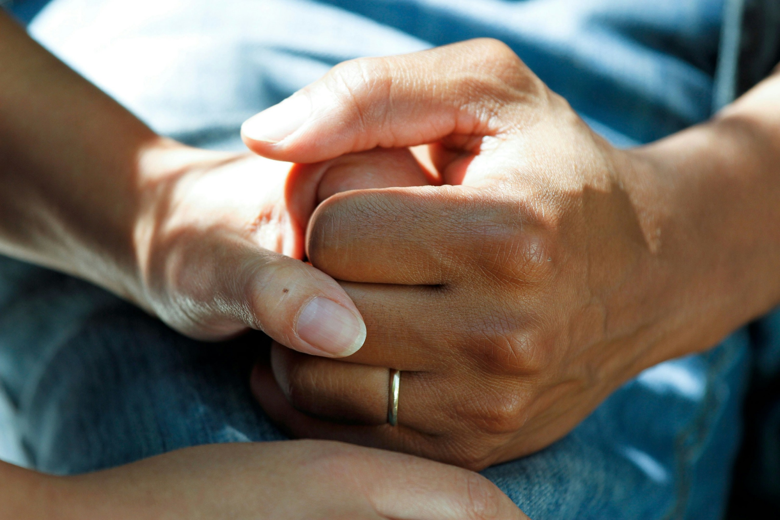 close on two people holding hands - photo by national cancer institute