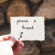 person holding a piece of paper with "phone a friend" written text | photo by dustin belt