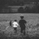 three kids running on a field - photo by jordan whitt