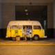 woman and child standing in front of yellow bus in car park - photo by dmitry nucky thompson