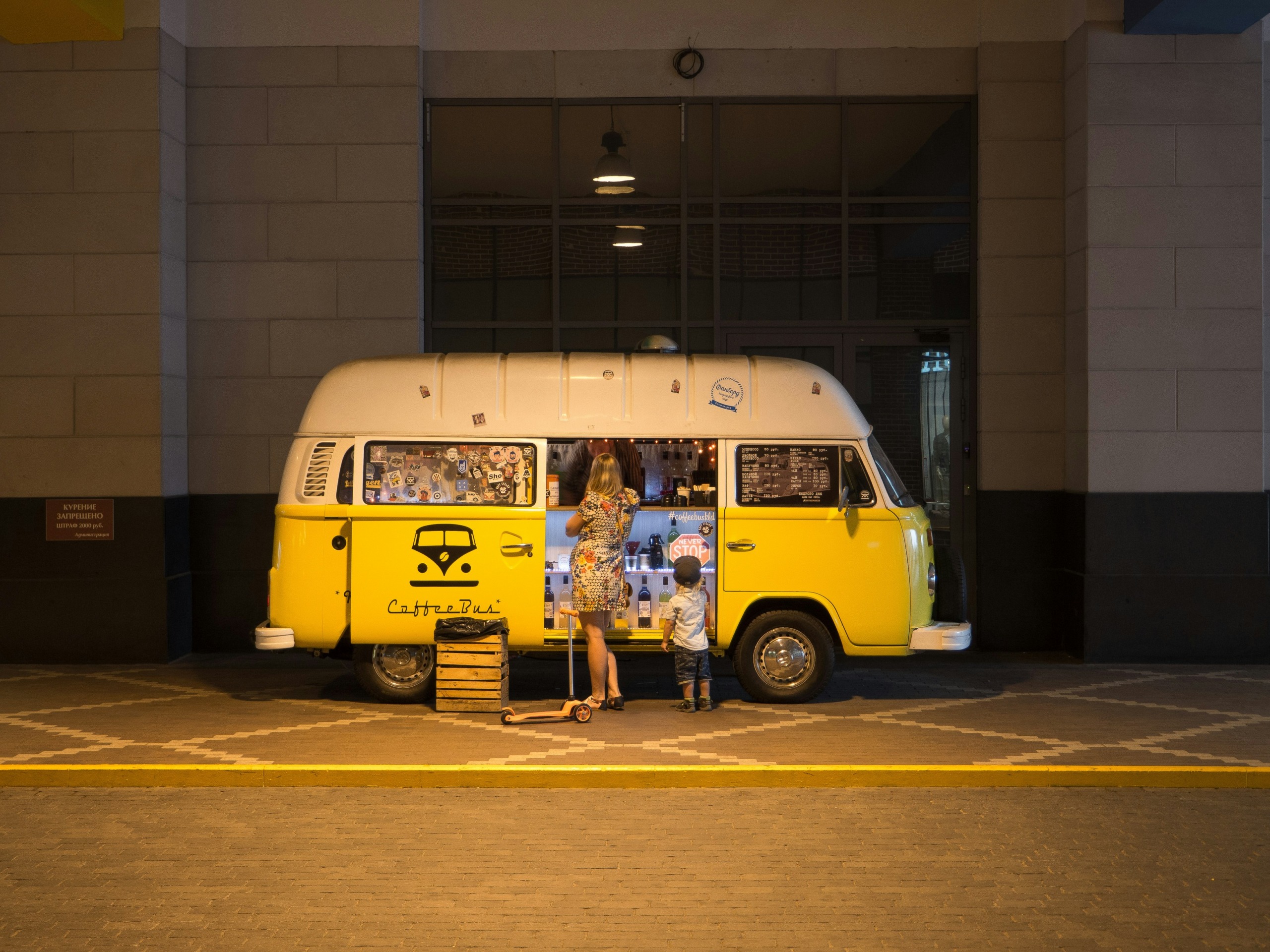 woman and child standing in front of yellow bus in car park - photo by dmitry nucky thompson